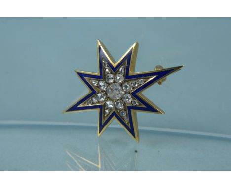 An unmarked yellow metal blue enamel and diamond star form brooch, the large centre old cut diamond with graduating diamond b