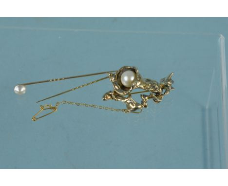 A flower form brooch set with single pearl and two stick pins, one pearl set