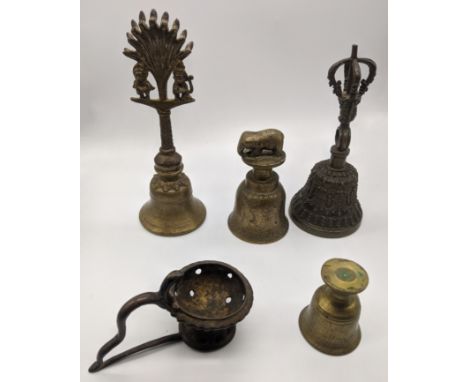 A collection of Tibetan brass ritual items to include bells and an oil lamp, Tibet