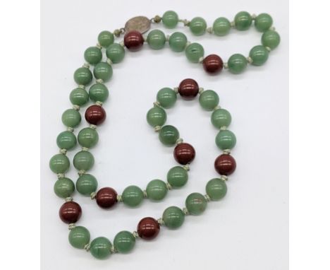 A Jade bead necklace, silver clasp