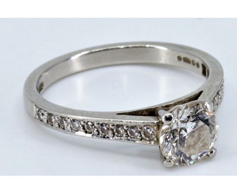 An impressive diamond and platinum engagement ring, central round brilliant cut diamond (approx. 1.28 carats). Flanked by two