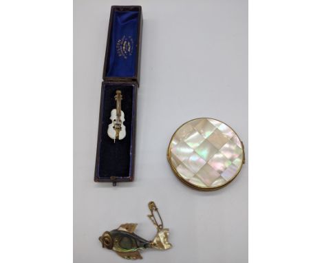 A mother of pearl violin brooch, mother of pearl compact and a fish brooch