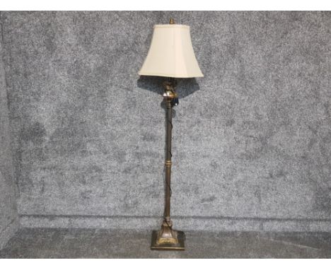 A lacquered metal and marble standard lamp with cream shade.