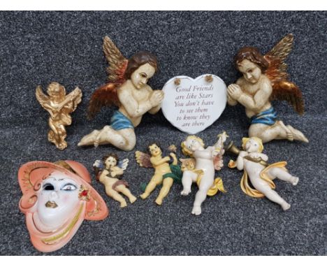 A pair of painted wooden cherubs, other cherubs and an art deco style ceramic wall plaque in the form a woman.