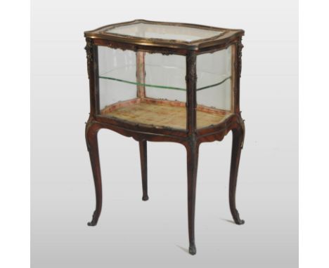 A late 19th century French kingwood vitrine, of serpentine shape, with gilt metal mounts, containing a glass shelf, enclosed 