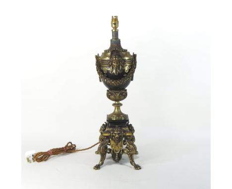 A large and ornate gilt metal and black marble table lamp, of urn shape, on paw feet, 67cm high