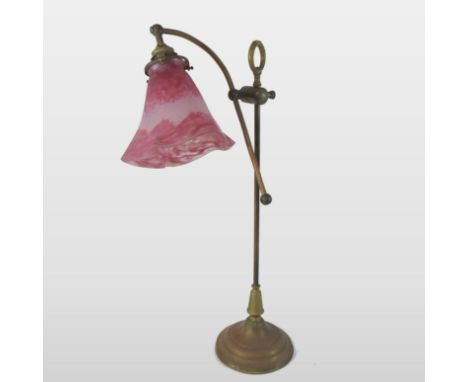 A French brass adjustable table light, with an opaque red frilled glass shade, signed Daum Nancy, 55cm high overall