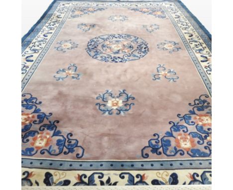 A large Chinese woollen carpet, the central medallion on a pink ground, within multiple borders, 350 x 560cm