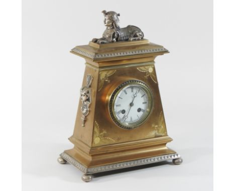 A 19th century brass cased Egyptian revival mantel clock, the enamel dial showing Roman hours with an eight day drum movement