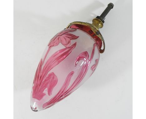 An Art Nouveau pink overlaid glass light shade, decorated with stylised daffodils, on a gilt metal mount, 29cm
