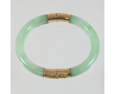 A Chinese jade and 14 carat gold mounted bangle, the hinge decorated with bamboo, the clasp decorated with a dragon, 8cm diam