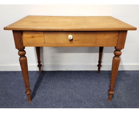 PINE SIDE TABLEthe single drawer with floral decorated ceramic knob, raised on turned supports, 96cm x 75.6cm x 60cm
