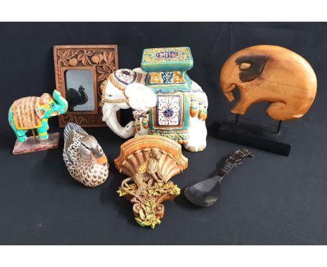 THREE ELEPHANT ORNAMENTScomprising a ceramic elephant jardiniere stand, 27cm high; and two carved wooden elephants, one of mo