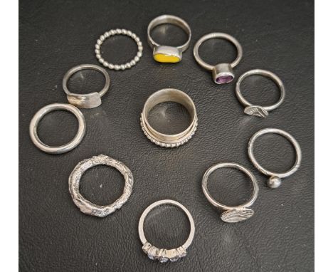ELEVEN SILVER RINGSincluding a spinner ring, an amethyst set ring, a yellow enamel set example, etc. (11)