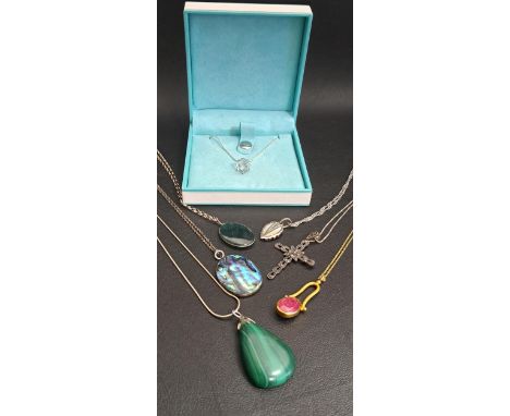 SELECTION OF SEVEN SILVER AND SILVER MOUNTED PENDANTSincluding a New Zealand Paua Shell pendant, a marcasite set cross pendan