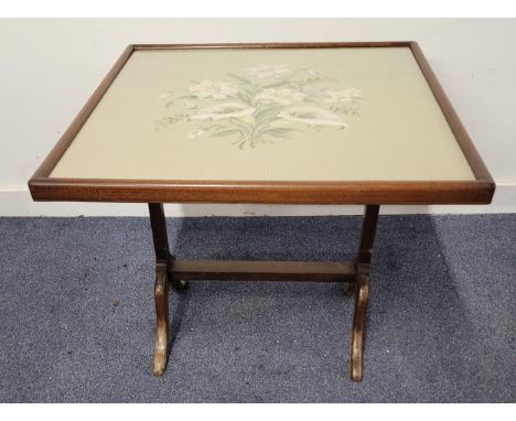 MAHOGANY FRAMED FOLDING FIRE SCREEN/ OCCASIONAL TABLEthe embroidered panel depicting lilies, the panel frame measuring 63.5 x