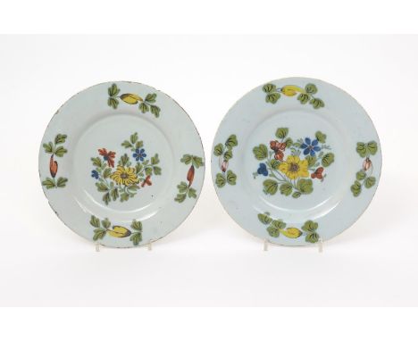 A pair of Dublin delftware plates  c.1760, simply decorated with bold flower sprays in yellow, red, blue and green, numeral m