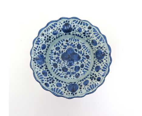 A small lobed delftware dish  late 17th century, probably London, decorated with a stylized floral design echoed to the rim, 