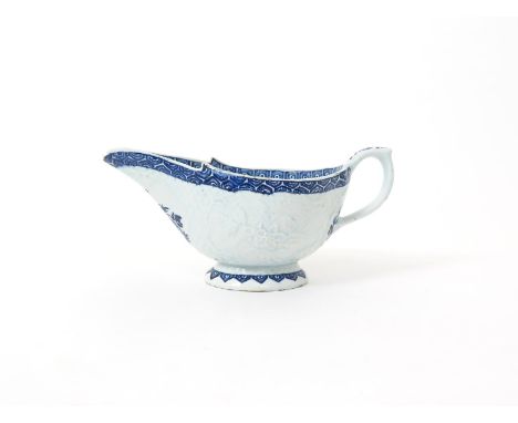 A large Bow blue and white sauceboat  c.1765, the exterior moulded with a floral panel to each side reserved on an overlappin