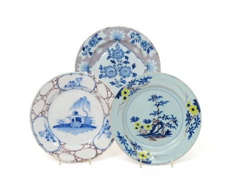 Three delftware plates  mid 18th century, one Bristol and painted with a blue flower spray within a woolpack shaped panel on 