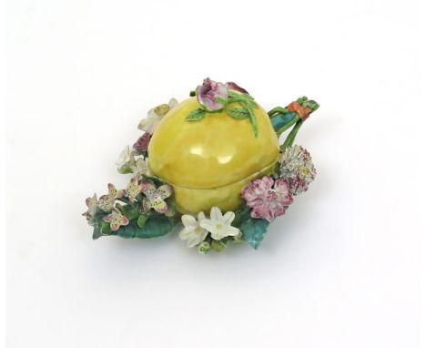 A rare Chelsea lemon box and cover  c.1754, modelled as a large citrus fruit forming part of a posy with stems of flowers aro