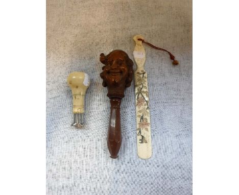 AN IVORY HANDLED DESK SEAL, a similar bone letter opener and a carved wooden nutcracker 