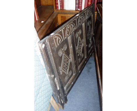 A 17TH CENTURY PANELLED OAK BED HEADBOARD, with carved decoration, rope holes and with sockets for the original wheels, 41" w