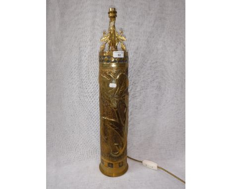 A WORLD WAR I BRASS SHELL CASE, dated 1916 with heavily embossed decoration (converted to a table lamp)