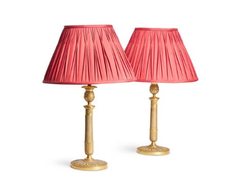 A PAIR OF FRENCH EMPIRE STYLE GILT BRASS TABLE LIGHTS  19TH CENTURY AND LATER  Engine turned stems above leaf cast bases with