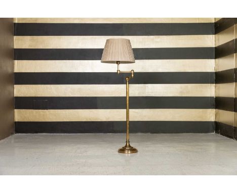 A brass standard lamp, of recent manufacture, with a rotating arm over a plain shaft and circular base, shade not included,28