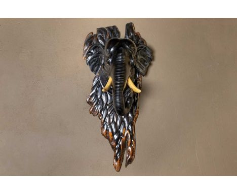 A carved ebony elephant head, c.1900, Ceylonese, with imitation ivory tusks, 33cm wide27cm deep76cm highCondition ReportAreas