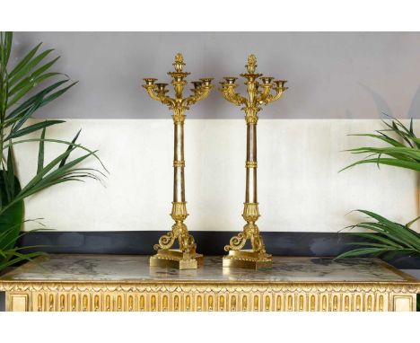 A pair of Charles X six-branch candelabra, c.1830, each with foliate ormolu mounts and silvered column, on a scrolling trifor