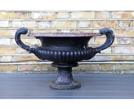 A cast iron campana urn, late 19th century, with scrolling handles, on a pedestal circular foot,52cm diameter43cm highConditi