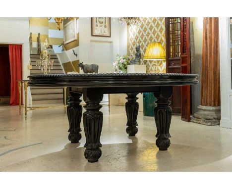 A large ebonised mahogany centre table,  early 20th century, Anglo-Indian, the circular top with a gadrooned edge and raised 