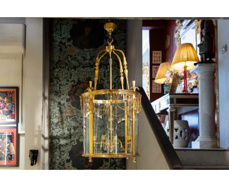 A Louis XVI-style gilt-bronze hall lantern,  c.1900, with scrolling decoration and swag detail, the central column issuing fo