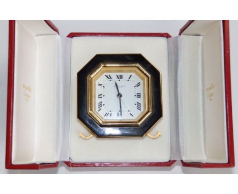 A  cased Cartier alarm clock of octagonal shape with black enamel borders on gilt metal- 7507 07135 – 2.9” across – with orig