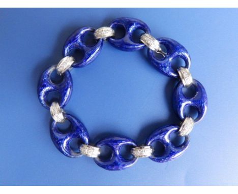 A blue guilloche enamel bracelet, interspersed with smaller semi-circular '750' white metal links set small diamonds, 7.25”