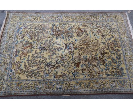 Qum rug with an all-over hunting design on a pale yellow ground with borders, 210 x 135cm