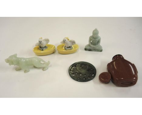 Carved jade figure of a lion, another of a Buddha, a pierced jade disc carved with a figure of a bird, carved stone snuff bot