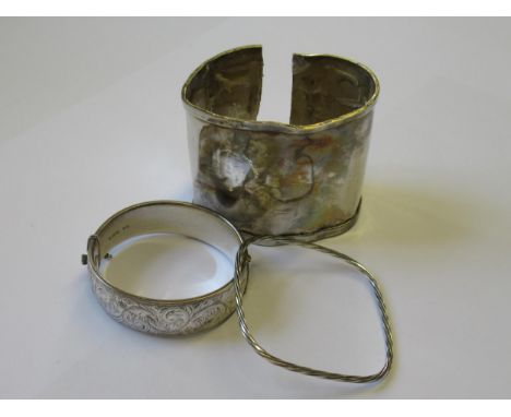 Two silver bangles, together with a silver cuff (at fault), 4.9oz tLarge cuff is very badly bent and dented. Engraved bangle 