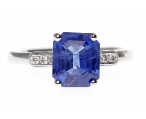 SAPPHIRE AND DIAMOND RINGset with a central emerald cut sapphire 8.1x6.9x4.3mm flanked by three round brilliant cut diamonds 