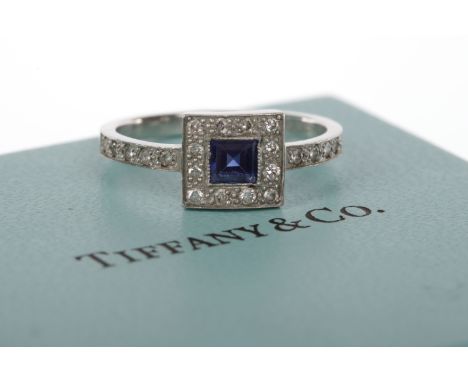 TIFFANY & CO. PLATINUM SAPPHIRE AND DIAMOND CLUSTER RINGthe square bezel 8mm wide and set with a central square step cut sapp