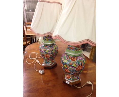 Pair of large floral ceramic lamps with shades and wooden bases.