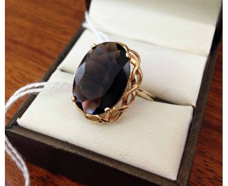 9ct gold ring set with very large oval smokey quartz stone in a pierced mount. Size R½.