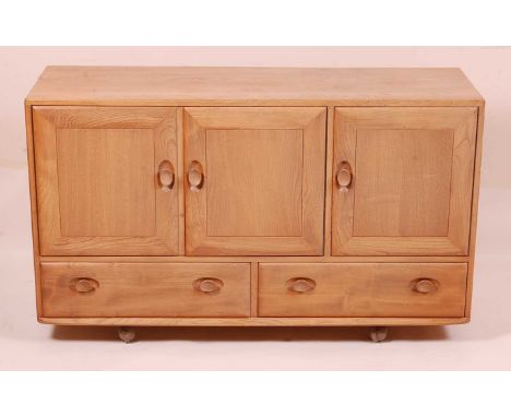 An Ercol light elm Windsor sideboard, the three cupboard doors over twin lower drawers, to roller castors, w.130cm, h.76cm, d