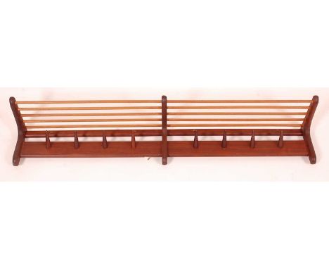 A Younger Ltd - a 1960s teak long Pullman style wall-mounted coat rack, having eight conical shaped pegs, w.121.5cmCondition 