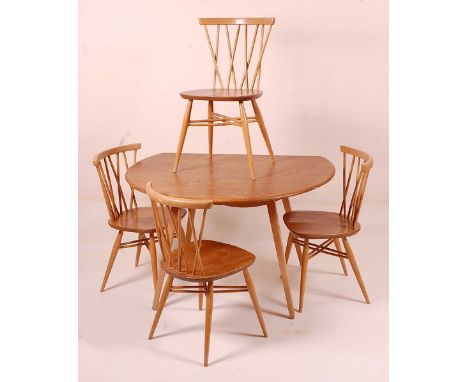 A 1960s Ercol blond elm breakfast suite, comprising; dropleaf table, having oval fall leaves and raised on slightly tapering 