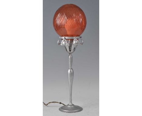 An Art Deco silvered metal table lamp, having a red tinted etched glass globular shade, raised on stylised petals to turned c