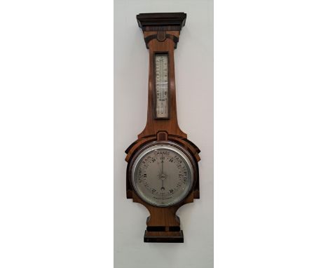 WALNUT ANEROID BAROMETERwith a silvered thermometer above a circular silvered dial, 66.5cm high 