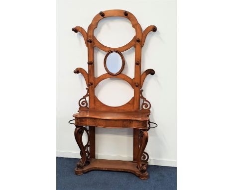 VICTORIAN OAK HALL STANDthe shaped back with twelve hat pegs and a central oval mirror above a serpentine shelf with a centra